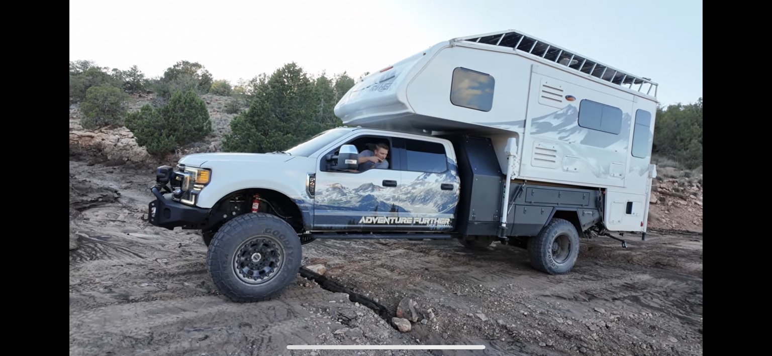 Ford F-450 with a truck camper on a rocky trail